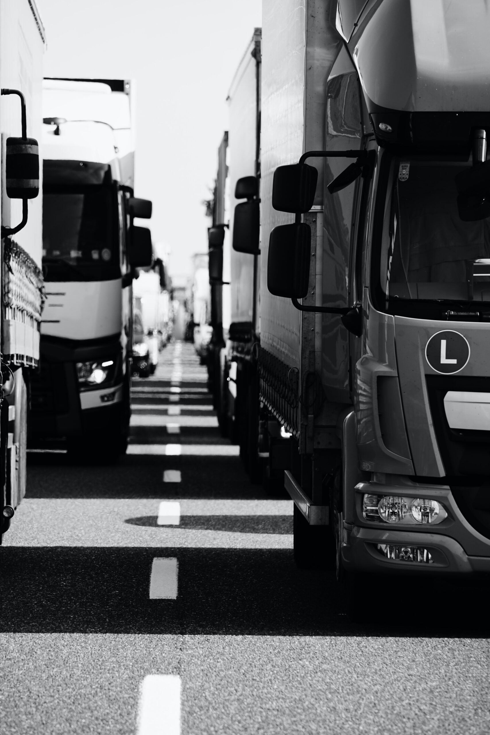 Black and white photo of a line up of lorrys on the motorway